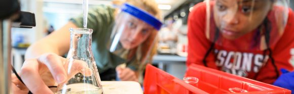 Students in the second semester of general chemistry, CHEM 104, watch carefully for the liquid in the beaker to turn from blue to yellow as they work on a lab where they use titration to identify an unknown base while working in the 7th floor general chemistry labs in the new instructional tower addition to the Chemistry Building at the University of Wisconsin–Madison on April 13, 2022. (Photo by Althea Dotzour / UW–Madison)