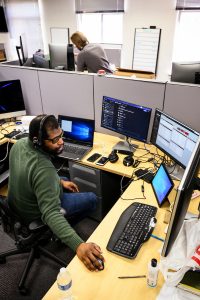 Considered essential staff under COVID-19, Division of Information Technology (DoIT) staff Alex Robinson (foreground) and Ben Pommerening provide desktop computer technical support while working in Rust-Schreiner Hall at the University of Wisconsin-Madison on April 15, 2020. The majority of the UW-Madison campus is closed in response to the rapidly-evolving health concerns of the global coronavirus (COVID-19) pandemic. (Photo by Jeff Miller / UW-Madison)