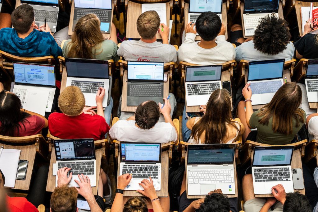 Students follow along with the lecture on their laptops in Chemistry 103 in Agricultural Hall at the University of Wisconsin-Madison during the first morning of classes for the fall semester on September 8, 2021. The campus health mandate requires people to wear a face mask indoors – except while eating or drinking – as the coronavirus (COVID-19) pandemic continues. No face covering is required when outdoors. (Photo by Althea Dotzour/UW-Madison)